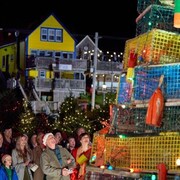 Des personnages du film Christmas Island regardent un sapin de Noël faits en casiers à homards.