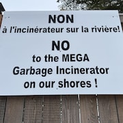 Une affiche, apposée sur une clôture de bois, sur laquelle il est écrit « NON à l'incinérateur sur la rivière! ».