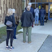Des électeurs font la file pour entrer dans un bureau de vote.