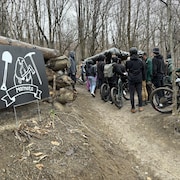 Des cyclistes regroupés dans un sentier de vélo de montagne dans un secteur boisé.