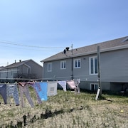 Une maison dans une communauté et du linge étendu sur une corde à l'avant-plan.