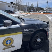 Une voiture de la Sûreté du Québec bloque une rue. 