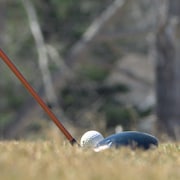 Une image d'une balle de golf en train d'être frappée. 