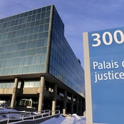 L'édifice du palais de justice de Québec en hiver avec, à l'avant-plan, l'enseigne l'annonçant marquée du numéro 300.