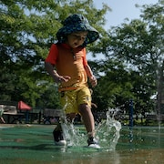 Des enfants s'amusent dans des jeux d'eau à Montréal. 