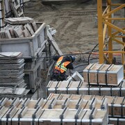 Un travailleur à l'ouvrage au milieu de boîtiers sur un chantier de construction.