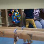 Un adulte à genoux près d'un enfant dans une garderie.