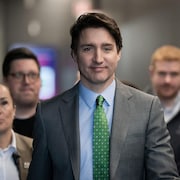 Justin Trudeau marche entour de son quipe.