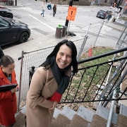 Valérie Plante, mairesse de Montréal, monte les marches d'une maison de chambres dans Ville-Marie.
