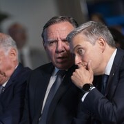 Trois hommes politiques assis ensemble.