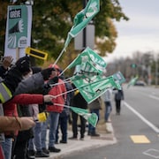 Plusieurs personnes brandissent des pancartes avec l'inscription : En grève.