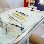 Un plateau de dentiste sur lequel sont disposés des instruments sur un morceau de tissu.