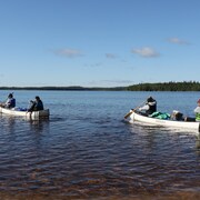Quatre jeunes à bord de deux canots.