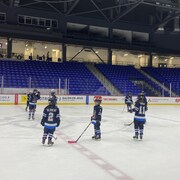 Des hockeyeuses au centre d’une patinoire.