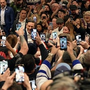 Le chef conservateur Pierre Poilievre entouré d'une foule de militants tenant des téléphones cellulaires.