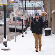 Un piéton se promène au centre-ville de Regina, en Saskatchewan, après une tempête de neige, le 7 novembre 2023.