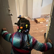 Jeilyn âgée de 4 ans regarde un appartement insalubre.
