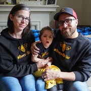 Deux parents posent avec leur fille.