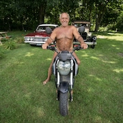Un homme tout nu sur une moto.