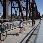 Des cyclistes qui roulent le long d'un pont.