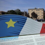 Une plaque décorée d'une représentation du drapeau de l'Acadie décrit l'Université Sainte-Anne.