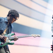 Rivers Cuomo regarde sa guitare en faisant un solo.