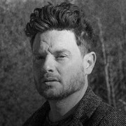Un portrait noir et blanc du chanteur Yann Perreau, vu de profil.