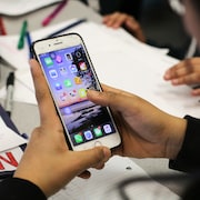 Des adolescents consultent leurs téléphones cellulaires.