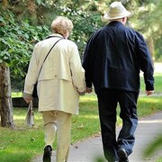 Un homme et une femme âgés marchent sur un sentier. 