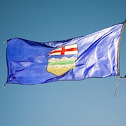 Le drapeau de l'Alberta flotte au vent.