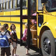 Des enfants montent dans un autobus scolaire