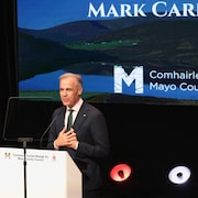 Mark Carney s'exprime derrière un lutrin.