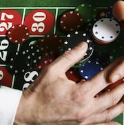 un tapis de jeu de casino avec des jetons, des mains en train de se saisir de tous les jetons