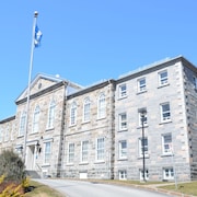 Un immeuble en brique avec un drapeau du Québec à l'avant.
