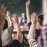 Adolescents levant la main en classe.