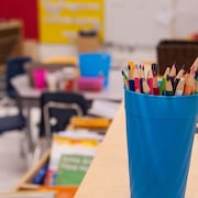 Une classe vide; des crayons en avant-plan.