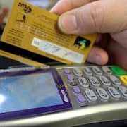 Une personne paye un achat avec sa carte de crédit.