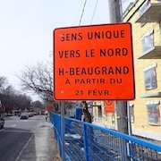 Un grand panneau orange indiquant que la rue Honoré-Beaugrand est devenue un sens unique.