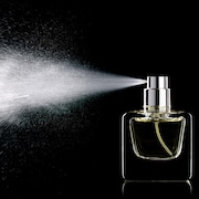 Du parfum vaporisé jaillit d'un flacon.