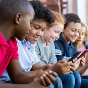 Des enfants utilisant un téléphone intelligent.