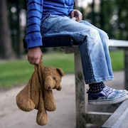 Un enfant est assis dans des gradins avec son toutou.
