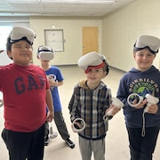 Quatre jeunes portent un casque de réalité virtuelle.