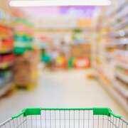 Un panier à roulettes dans une allée d'épicerie