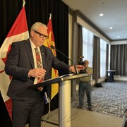 Ernie Steeves devant des drapeaux.