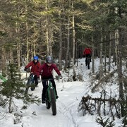 Trois jeunes sur des vélos à pneus surdimensionnés en hiver. 