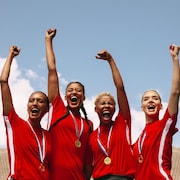 Joueuses de soccer professionnelles célébrant une victoire, médaille au cou.