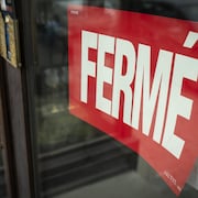 Une pancarte « fermé » sur la porte d'un commerce.