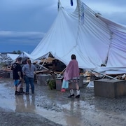Un chapiteau de festival effondré au sol.
