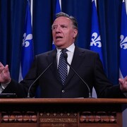 Un homme, l'air soucieux, est derrière un lutrin lors d'une conférence de presse.