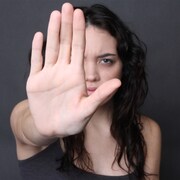 Un femme avec sa main devant elle, comme pour repousser quelqu'un